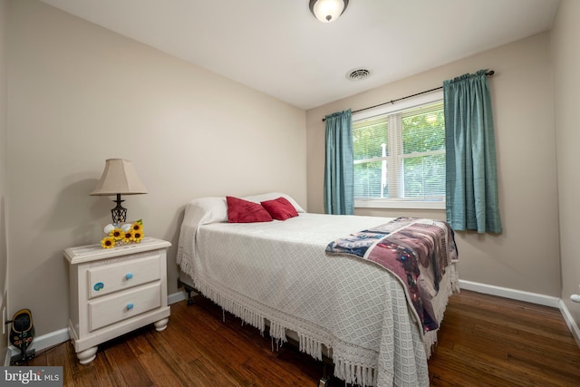 bedroom with dark wood-type flooring, visible vents, and baseboards