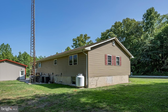 back of property featuring central AC and a yard