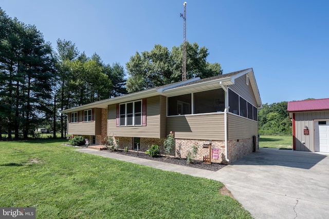 split foyer home with a garage, a front lawn, a sunroom, and an outdoor structure