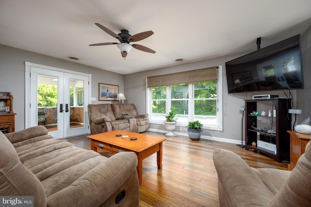 living room with ceiling fan, plenty of natural light, light hardwood / wood-style floors, and french doors