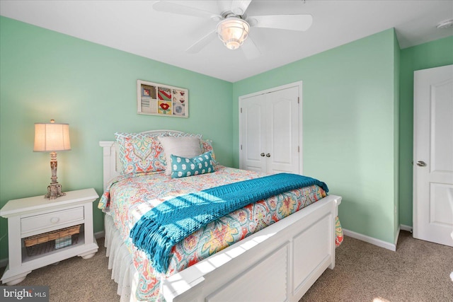 bedroom featuring a closet, light colored carpet, ceiling fan, and baseboards