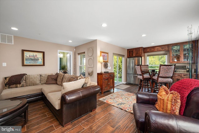 living area featuring visible vents, dark wood finished floors, and recessed lighting