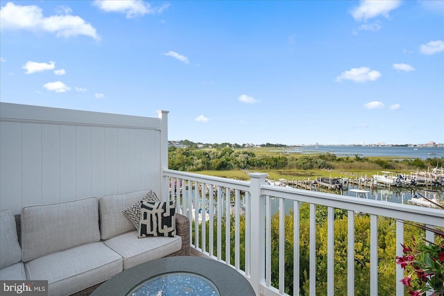 balcony with an outdoor living space and a water view