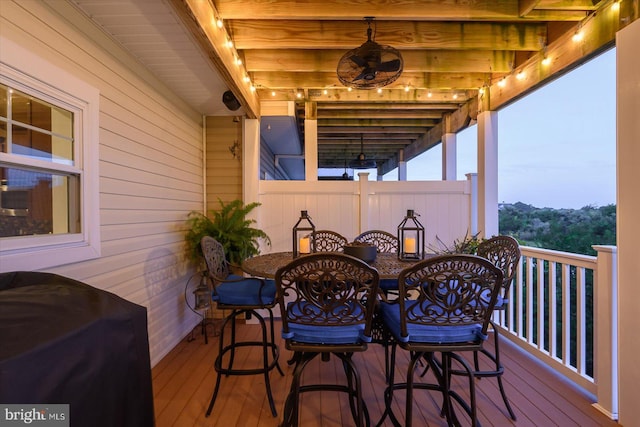 wooden deck featuring outdoor dining area and a ceiling fan