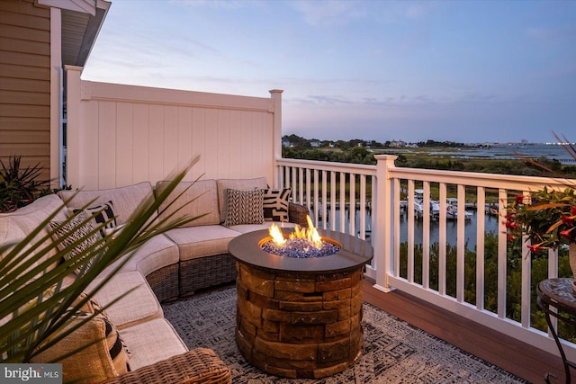 balcony with a water view and a fire pit