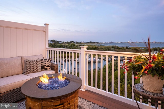 balcony featuring a water view and a fire pit