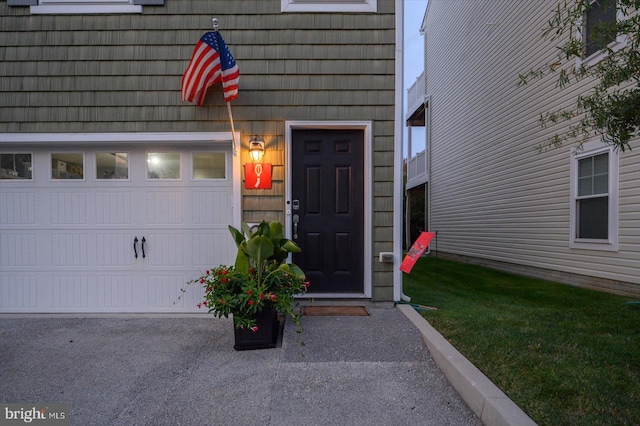 view of exterior entry featuring a garage and driveway