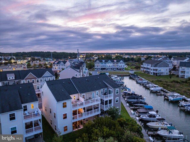 aerial view at dusk with a residential view and a water view