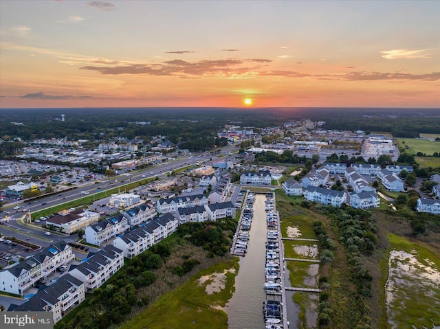 aerial view at dusk featuring a water view