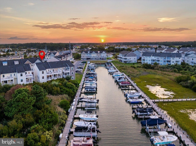 aerial view at dusk featuring a water view