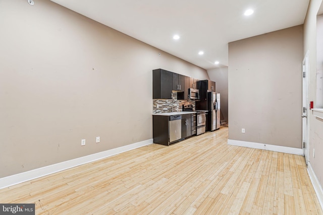 interior space featuring sink, tasteful backsplash, light hardwood / wood-style flooring, and stainless steel appliances