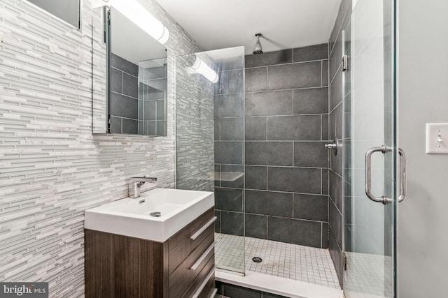 bathroom with tile walls, vanity, and walk in shower