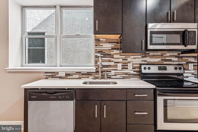 kitchen with dark brown cabinetry, sink, stainless steel appliances, and decorative backsplash