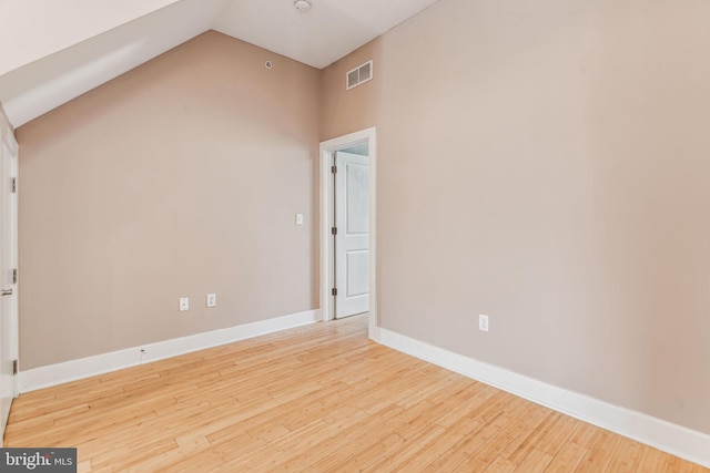 empty room featuring light hardwood / wood-style floors and high vaulted ceiling