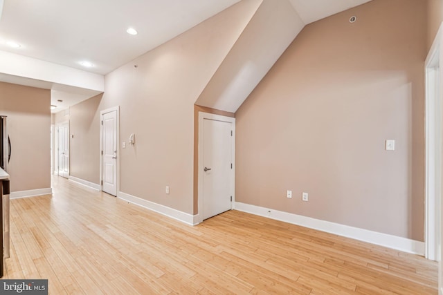 additional living space featuring vaulted ceiling and light hardwood / wood-style floors