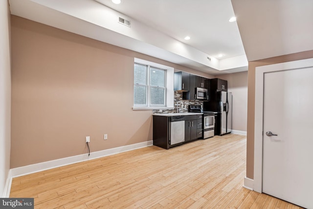 kitchen with light wood-type flooring, sink, stainless steel appliances, and tasteful backsplash