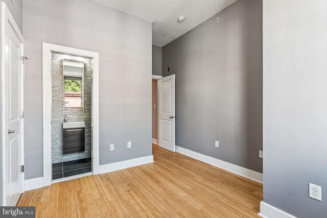 unfurnished bedroom featuring sink and light hardwood / wood-style floors