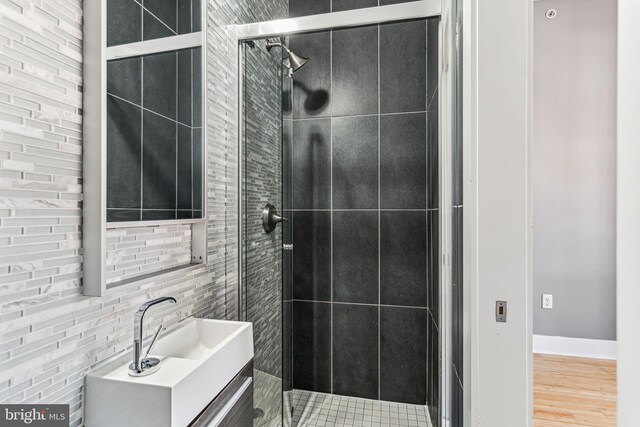 bathroom with an enclosed shower, vanity, and hardwood / wood-style floors