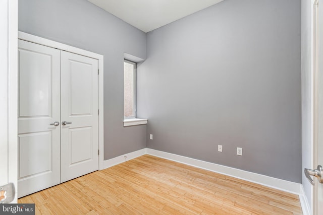 unfurnished bedroom with a closet and light hardwood / wood-style floors