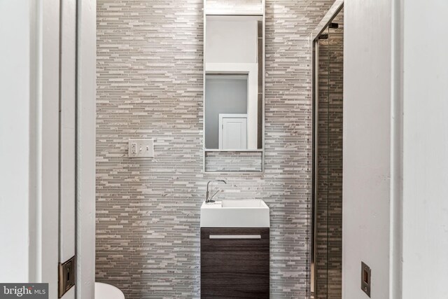 bathroom with vanity and tile walls