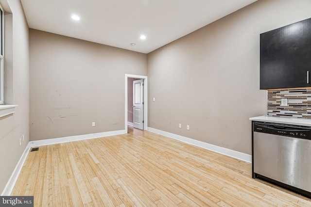 kitchen featuring dishwasher, decorative backsplash, and light wood-type flooring