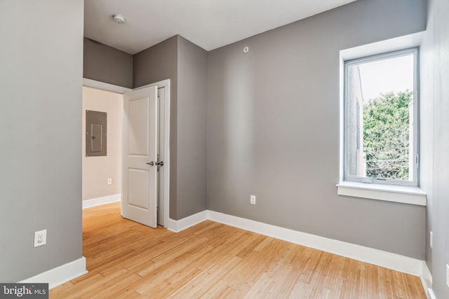 spare room with hardwood / wood-style floors and electric panel