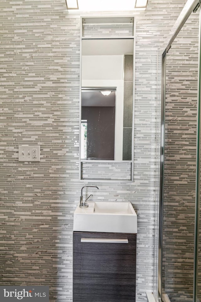 bathroom featuring tile walls, vanity, and walk in shower