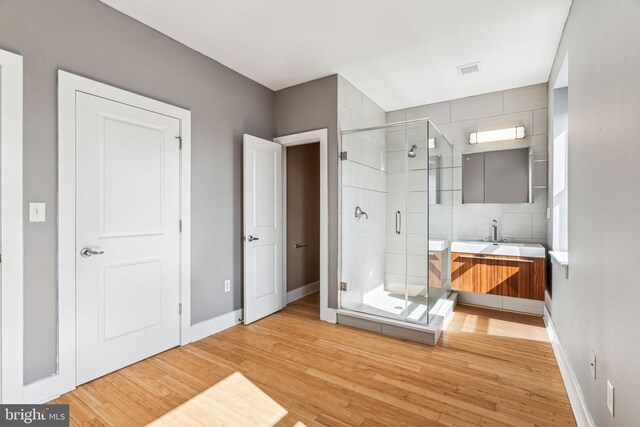 bathroom with an enclosed shower, hardwood / wood-style floors, and vanity