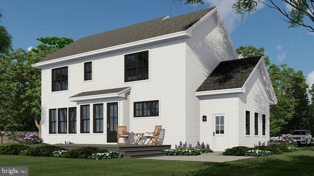 rear view of property with roof with shingles and a lawn