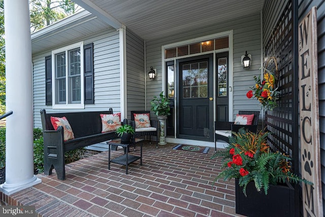 view of exterior entry featuring covered porch