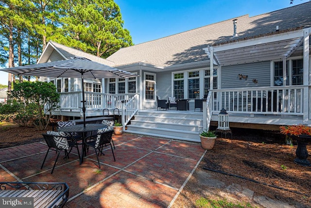 rear view of house featuring a shingled roof, a patio, a pergola, and a wooden deck