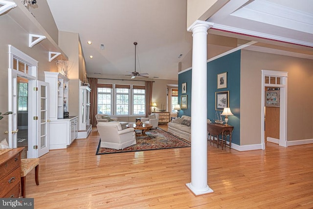 living area with ceiling fan, decorative columns, high vaulted ceiling, and light wood-style flooring