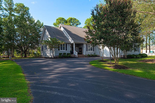 view of front facade with aphalt driveway and a front yard