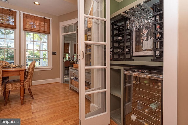 wine room with bar, wine cooler, and hardwood / wood-style flooring