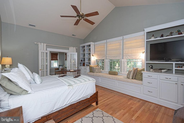 bedroom featuring high vaulted ceiling, light wood-style flooring, multiple windows, and visible vents