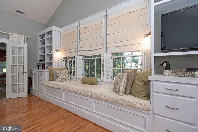 unfurnished room with light wood-type flooring, visible vents, and vaulted ceiling