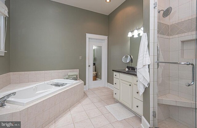 bathroom with tile patterned floors, independent shower and bath, and vanity