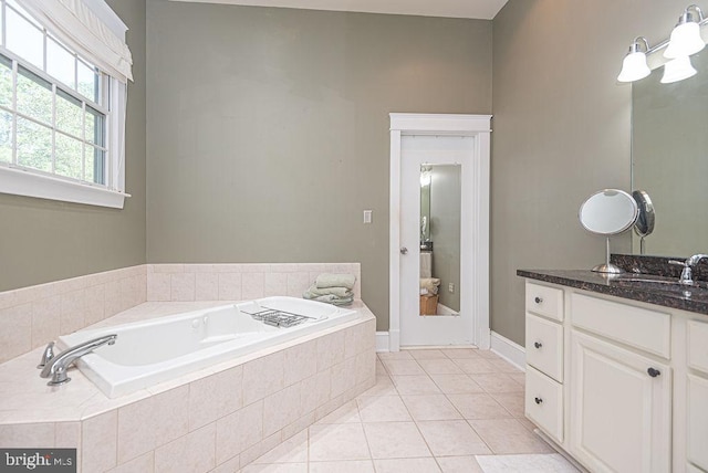 full bathroom featuring tile patterned flooring, a garden tub, vanity, and an inviting chandelier