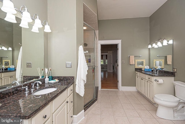 full bathroom with a stall shower, two vanities, a sink, and tile patterned floors