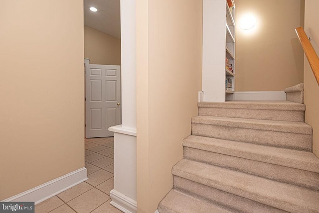 stairway with baseboards, recessed lighting, and tile patterned floors