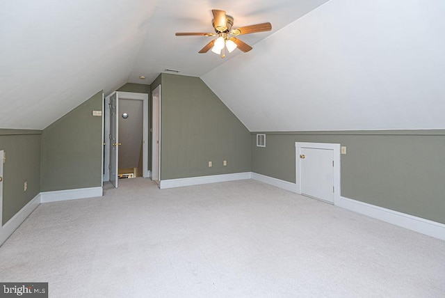 additional living space with ceiling fan, light colored carpet, and lofted ceiling