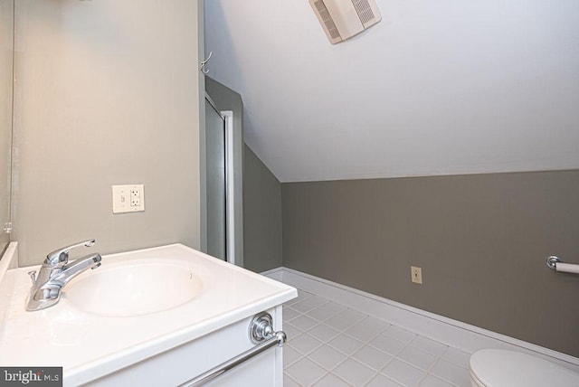 bathroom featuring baseboards, visible vents, toilet, vaulted ceiling, and vanity