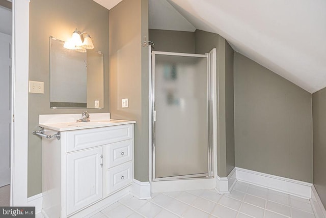 bathroom featuring baseboards, vaulted ceiling, a shower stall, and vanity