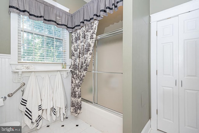 bathroom featuring tile patterned flooring and enclosed tub / shower combo