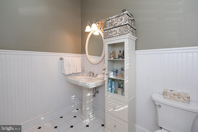 bathroom with a wainscoted wall and toilet