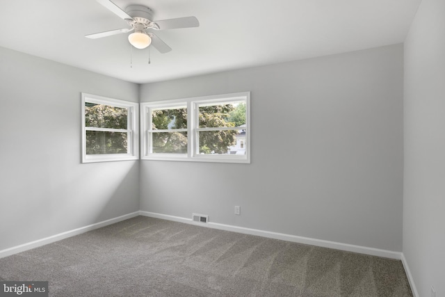 unfurnished room featuring carpet, visible vents, baseboards, and ceiling fan