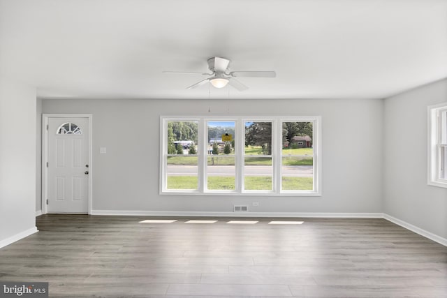 unfurnished living room with light wood-style floors, visible vents, ceiling fan, and baseboards