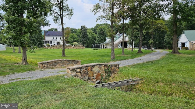 view of community featuring a yard and driveway