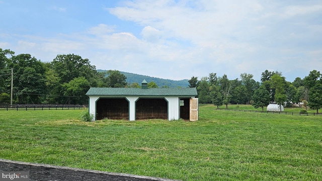 view of yard featuring a garage, fence, and an outbuilding