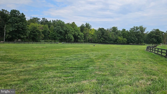 view of yard featuring fence and a rural view